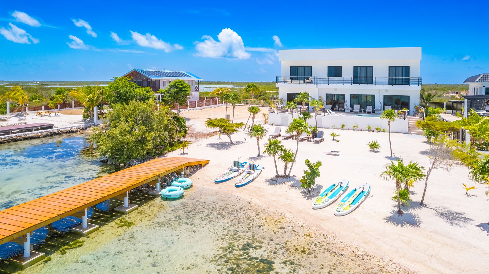 Aerial view of Black Orchid Oasis: the private dock, white-sand beach and the villa on the calm west shore of Ambergris Caye, Belize