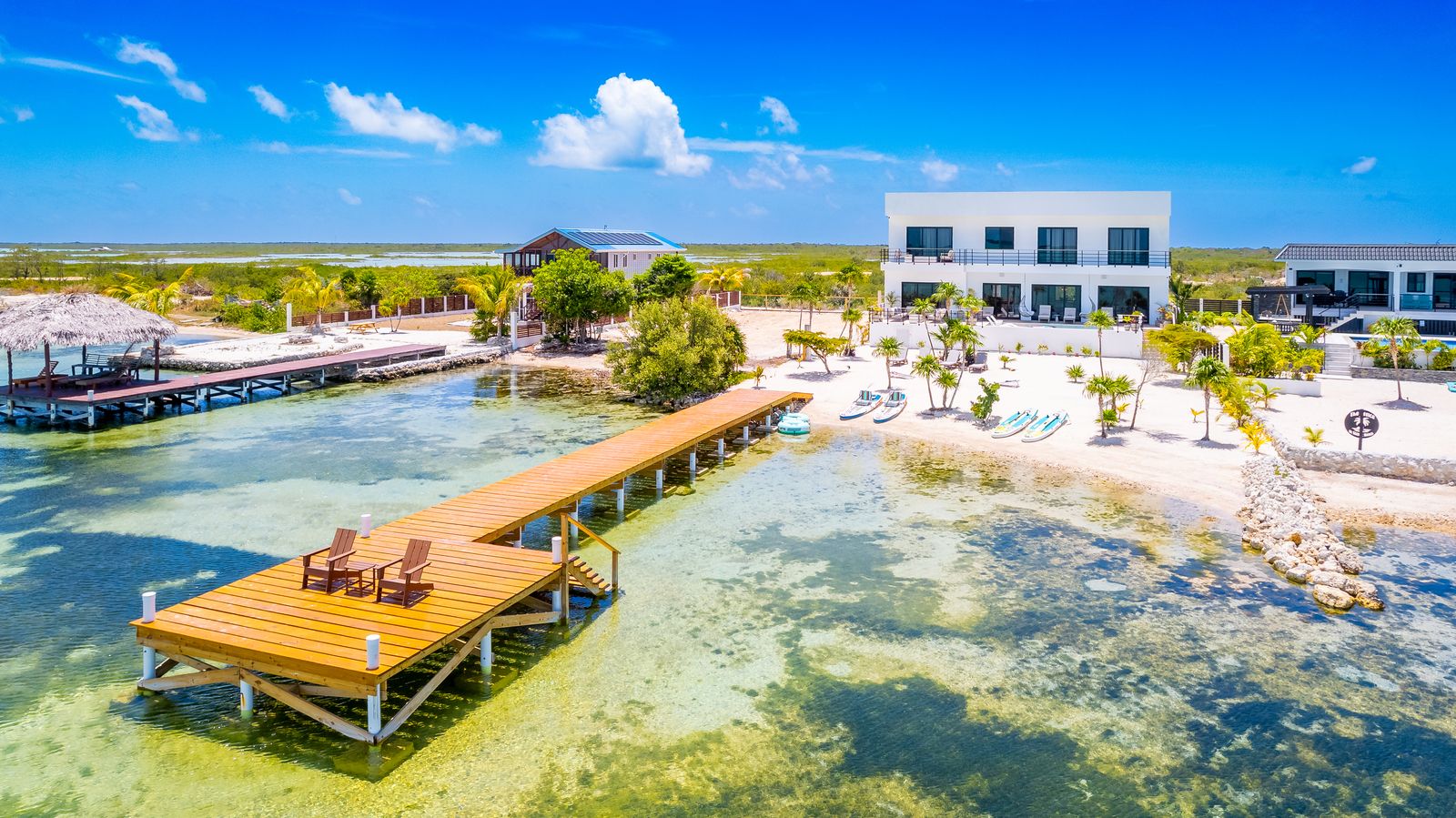 The private dock reaching into shallow, glass-clear water in front of the villa