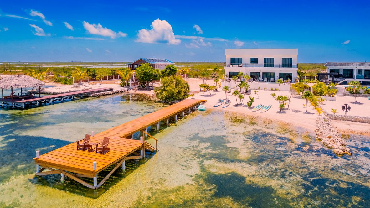 Aerial view of the estate: private dock, beach and villa on the calm west shore of Ambergris Caye