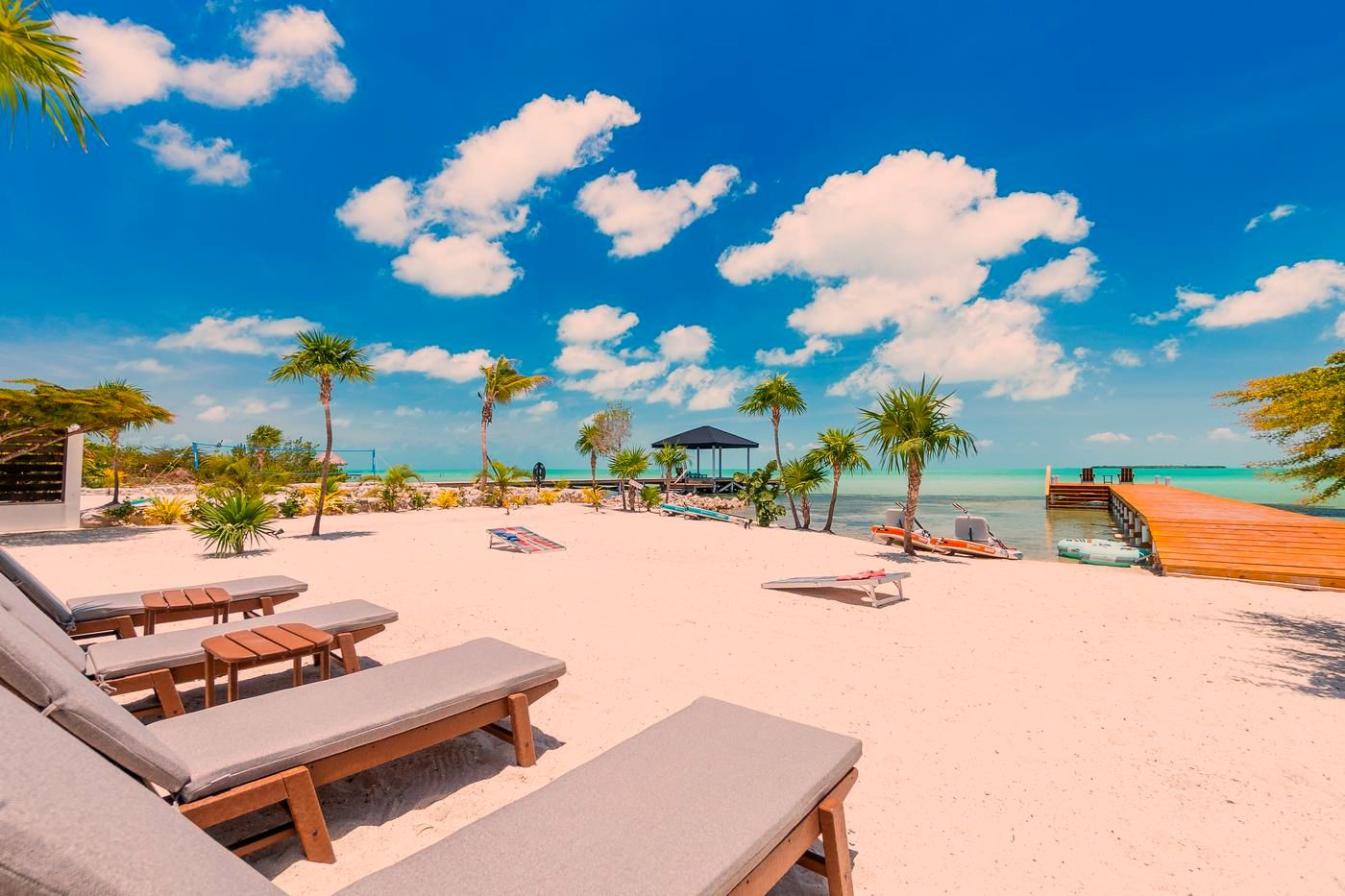 Loungers on the private beach in front of the villa, with palms and the dock, Secret Beach, Ambergris Caye