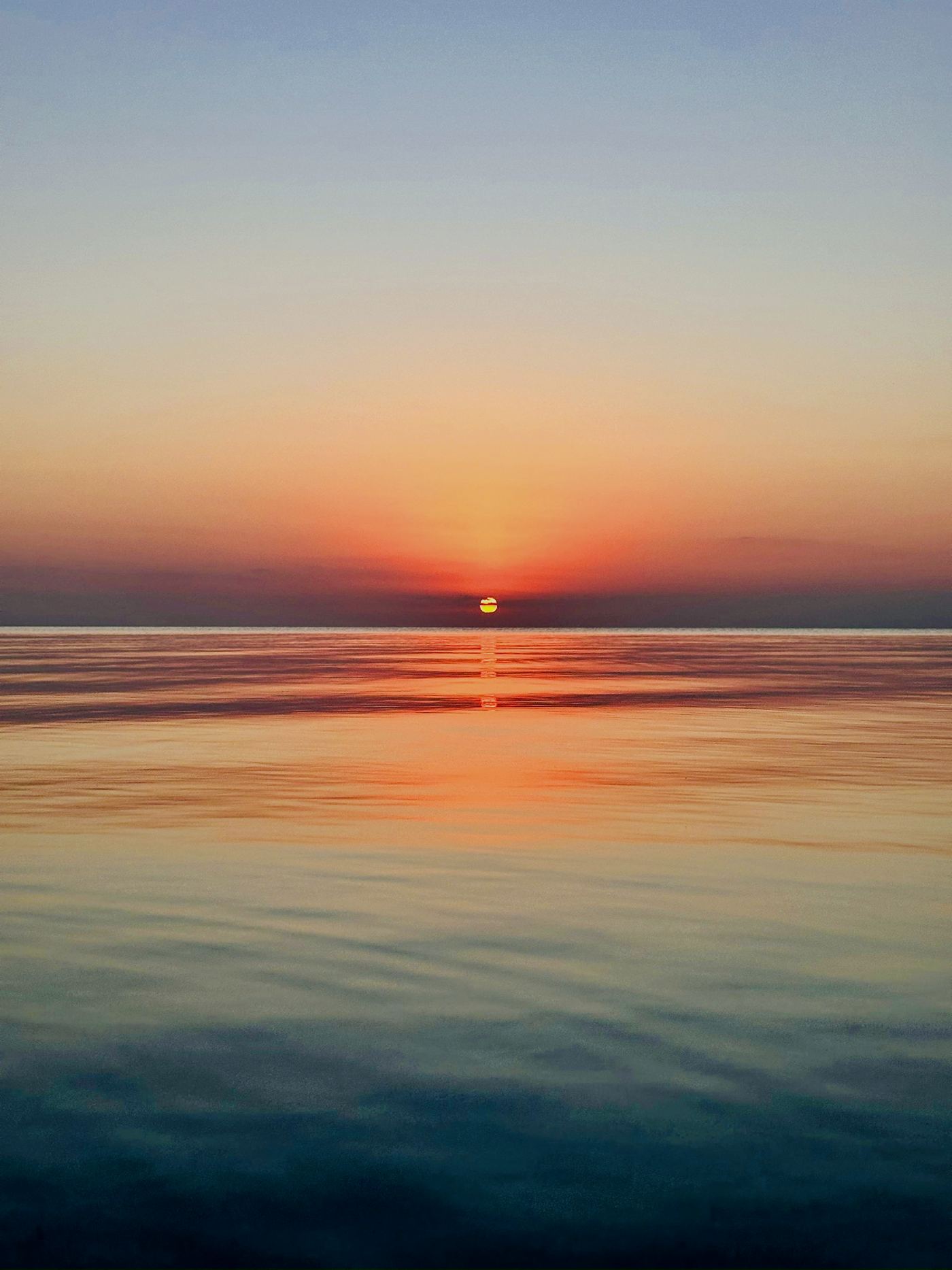 Sunset over calm water from the villa's west-facing shore