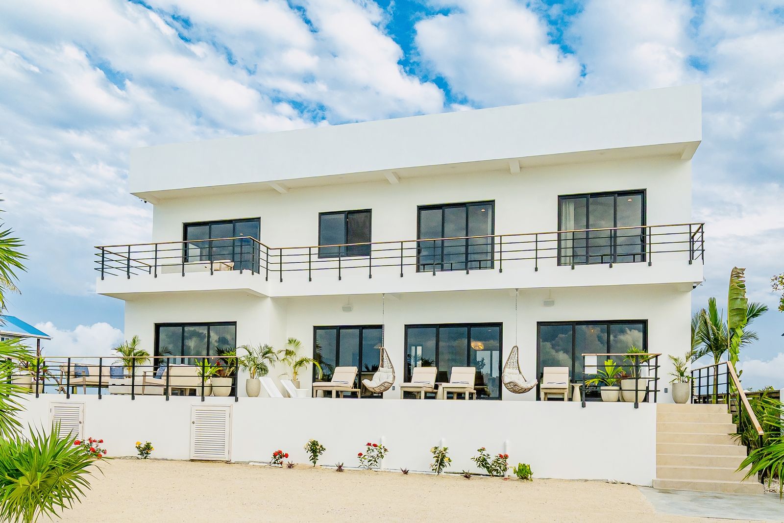 The villa seen from the beach: two floors of terraces facing the water