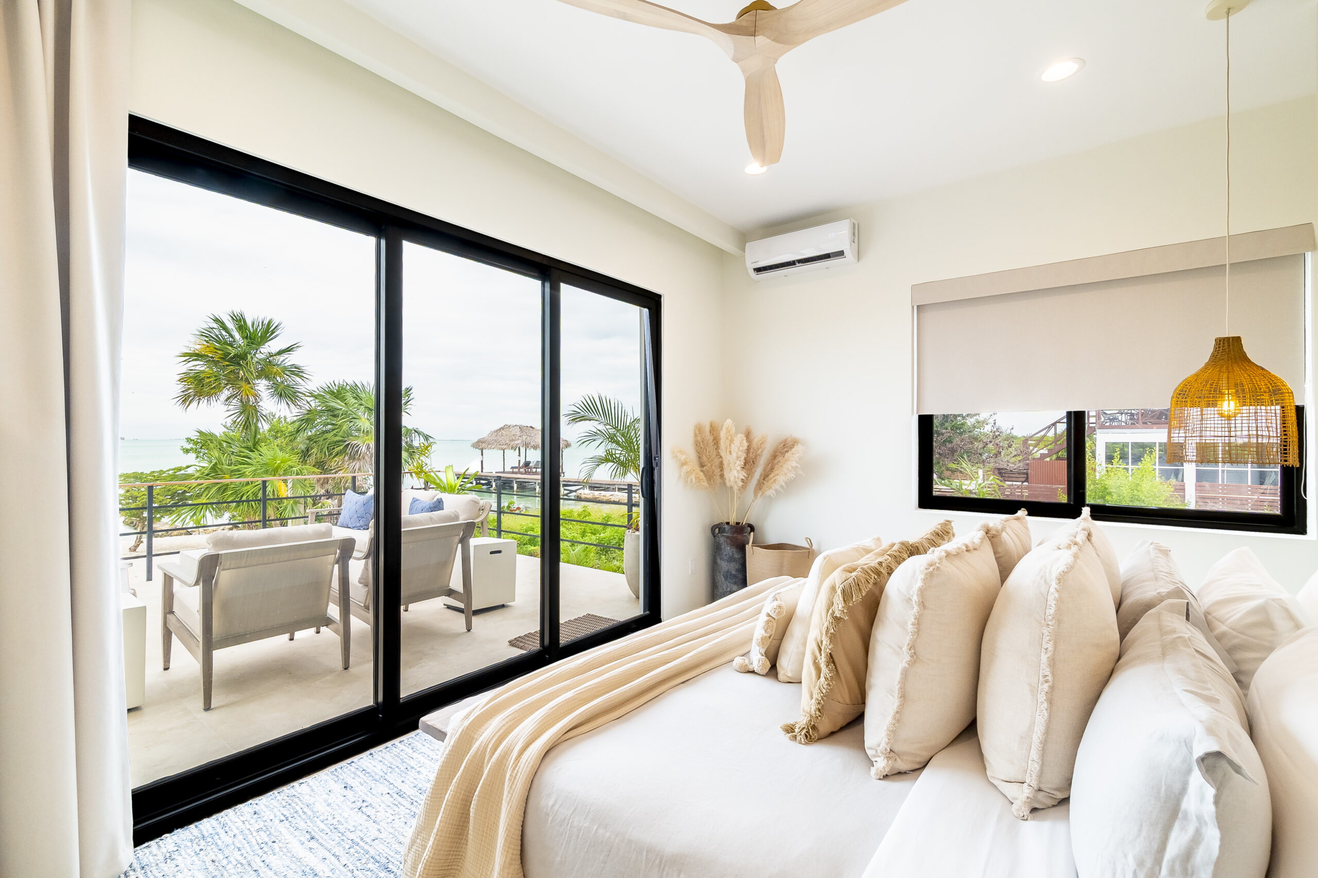 Luxury king bedroom with en-suite bathroom, oceanfront balcony, and modern tropical decor at Black Orchid Oasis in San Pedro, Belize.
