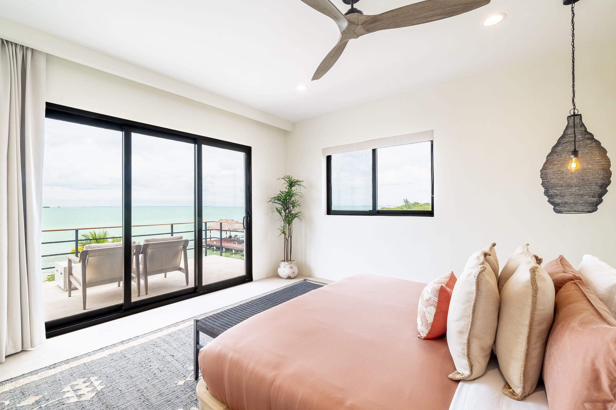 Luxury oceanfront en-suite bedroom with private balcony and Caribbean Sea views at Black Orchid Oasis in San Pedro, Belize.