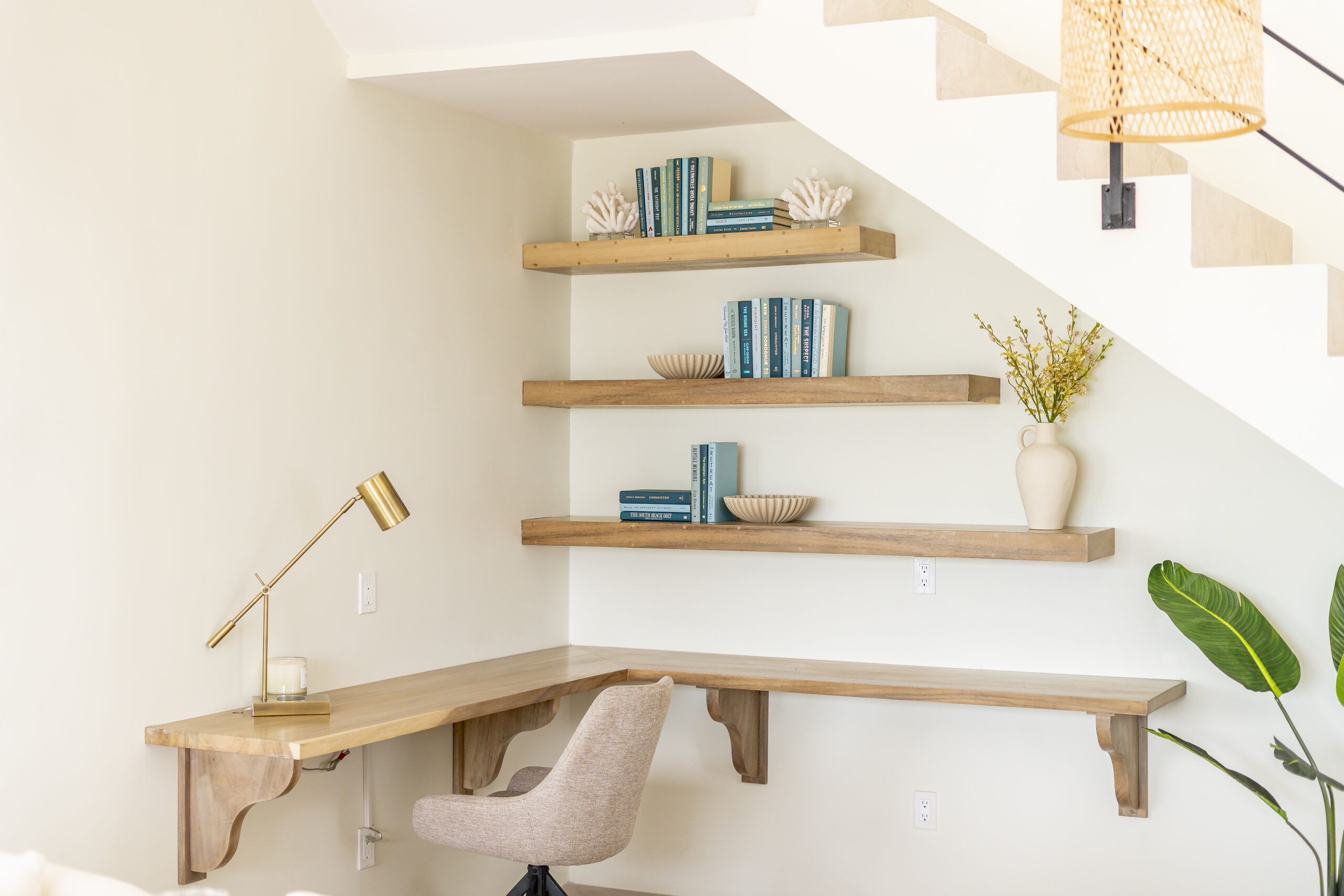 Modern built-in home office desk with floating wooden shelves and gold lamp at Black Orchid Oasis in San Pedro, Belize.
